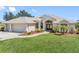 Charming single-story home with lush front lawn and a two-car garage, complimented by manicured landscaping at 182 Rotonda N Blvd, Rotonda West, FL 33947