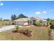 Charming single-story home with a manicured lawn, palm trees, and a wide driveway leading to a two-car garage at 182 Rotonda N Blvd, Rotonda West, FL 33947