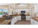 Updated kitchen features granite countertops, stainless steel appliances, and white cabinetry at 182 Rotonda N Blvd, Rotonda West, FL 33947