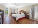 Bright main bedroom features tray ceiling, ceiling fan, wood floors, and sliding glass doors to the pool area at 182 Rotonda N Blvd, Rotonda West, FL 33947