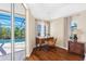 Bright office features a wooden desk, lots of natural light, and view of the pool area at 182 Rotonda N Blvd, Rotonda West, FL 33947