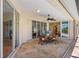 Enclosed patio featuring an outdoor dining table, ceiling fan, and access to the pool and home at 182 Rotonda N Blvd, Rotonda West, FL 33947