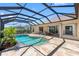 Enclosed pool featuring a unique shape, privacy landscaping and a stone patio with access to the home at 182 Rotonda N Blvd, Rotonda West, FL 33947