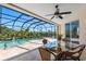 Enclosed pool featuring a patio area with an outdoor dining table and privacy landscaping at 182 Rotonda N Blvd, Rotonda West, FL 33947
