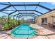 Enclosed pool featuring a unique shape, privacy landscaping and a stone patio with access to the home at 182 Rotonda N Blvd, Rotonda West, FL 33947