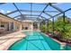 Enclosed pool featuring unique shape, privacy landscaping and a stone patio with access to the home at 182 Rotonda N Blvd, Rotonda West, FL 33947