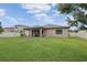 Large backyard with green grass and a covered patio at 18620 Cortes Creek Blvd, Spring Hill, FL 34610