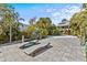 Inviting patio with lounge chairs, lush tropical landscaping, and a glimpse of the home and pool in the background at 249 Shore Dr, Palm Harbor, FL 34683