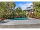 Relaxing pool area featuring a turquoise pool, spacious deck, and tropical landscaping for a serene outdoor experience at 249 Shore Dr, Palm Harbor, FL 34683