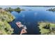 Scenic aerial view of a lake with a private dock and boats, surrounded by lush greenery at 2511 Dolly Bay Dr # 304, Palm Harbor, FL 34684
