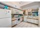 Kitchen with white appliances and cabinetry; open to the living area, promoting easy interaction at 2511 Dolly Bay Dr # 304, Palm Harbor, FL 34684