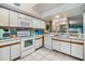 Bright kitchen with white cabinetry, appliances, and a tile backsplash at 2511 Dolly Bay Dr # 304, Palm Harbor, FL 34684