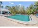 Large community pool with a cabana, surrounded by lounge chairs, and tropical foliage at 2511 Dolly Bay Dr # 304, Palm Harbor, FL 34684