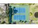 Overhead view of pristine tennis courts with green and blue surfaces, adjacent to a pond at 2511 Dolly Bay Dr # 304, Palm Harbor, FL 34684