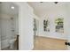 Bright bedroom featuring wood flooring, a mirrored sliding-door closet, and a connected bathroom at 2725 W Beach St, Tampa, FL 33607