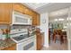 Cozy kitchen displaying stone backsplash, wood cabinets, and casual dining space at 2800 Cove Cay Dr # 3C, Clearwater, FL 33760