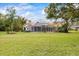 The backyard view showcases a screened lanai, mature trees, and a well-manicured lawn at 30 Stanton Cir, Oldsmar, FL 34677