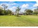 Expansive backyard featuring a screened-in pool, lush lawn, and mature trees, perfect for outdoor enjoyment at 30 Stanton Cir, Oldsmar, FL 34677