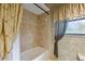 Bright bathroom features a bathtub, tiled walls, and a charming window with decorative curtains at 30 Stanton Cir, Oldsmar, FL 34677