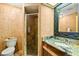 A full bathroom features a vanity with a granite top and a walk-in shower with glass door at 30 Stanton Cir, Oldsmar, FL 34677