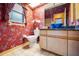 Bathroom featuring bright floral wallpaper, a vessel sink, and a window for natural light at 30 Stanton Cir, Oldsmar, FL 34677