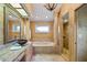 Luxurious bathroom featuring a soaking tub, elegant lighting, and walk-in shower with decorative pillar at 30 Stanton Cir, Oldsmar, FL 34677