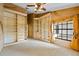 Bedroom with built-in shelving, neutral carpet, large window, and custom wall texture at 30 Stanton Cir, Oldsmar, FL 34677