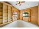 Bedroom with neutral carpet, built-in bookcase, and two windows with elegant curtains at 30 Stanton Cir, Oldsmar, FL 34677