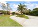 A home with a circular driveway surrounded by lush landscaping, showcasing a classic design at 30 Stanton Cir, Oldsmar, FL 34677