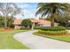 Single-story home with a circular driveway, tile roof, lush landscaping, and a welcoming entrance at 30 Stanton Cir, Oldsmar, FL 34677