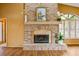 Living room featuring an elegant brick fireplace, complemented by hardwood floors and natural light at 30 Stanton Cir, Oldsmar, FL 34677