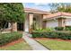 A single story home with a tile roof, brick accents, manicured landscaping, and a welcoming entrance at 30 Stanton Cir, Oldsmar, FL 34677