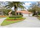 Inviting home exterior featuring a circular driveway, lush greenery, and a well-manicured lawn at 30 Stanton Cir, Oldsmar, FL 34677