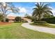 Charming single-story home with a well-manicured front yard, circular driveway, and lush landscaping at 30 Stanton Cir, Oldsmar, FL 34677
