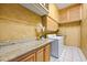 Functional laundry room with granite countertops, white appliances, and ample cabinet space at 30 Stanton Cir, Oldsmar, FL 34677