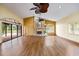 Bright living room features wood floors, fireplace, sliding glass doors to pool, and vaulted ceilings with fans at 30 Stanton Cir, Oldsmar, FL 34677