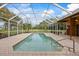 Covered pool with brick coping and a neutral stucco exterior, enclosed for added privacy and comfort at 30 Stanton Cir, Oldsmar, FL 34677
