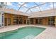 Covered pool featuring brick pavers and a neutral stucco exterior, ideal for relaxation and privacy at 30 Stanton Cir, Oldsmar, FL 34677