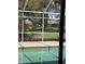 This shot through the screen of the pool shows a lush green golf course in the back at 30 Stanton Cir, Oldsmar, FL 34677