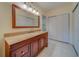 Bathroom showcasing a granite-topped vanity with a large framed mirror and a double-door storage closet at 30 Turner St # 203, Clearwater, FL 33756
