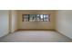 A bedroom with neutral colored walls and carpet features a large window at 30 Turner St # 203, Clearwater, FL 33756