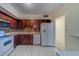 This well-lit kitchen features wood cabinets, stone countertops, and white appliances at 30 Turner St # 203, Clearwater, FL 33756