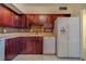 This well-lit kitchen features wood cabinets, stone countertops, and white appliances at 30 Turner St # 203, Clearwater, FL 33756