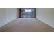 Inviting living room area featuring carpet flooring, neutral walls, and a sliding glass door with balcony at 30 Turner St # 203, Clearwater, FL 33756