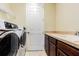 Laundry room featuring a white washer and dryer, counter space and white door at 3015 Northfield Dr, Tarpon Springs, FL 34688