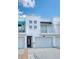 Contemporary white townhome featuring private balcony, a garage, and modern architectural details at 3101 W El Prado Blvd # B, Tampa, FL 33629