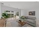 Cozy living room featuring a modern sofa, minimalist decor, and serene views of the outdoor courtyard at 3101 W El Prado Blvd # B, Tampa, FL 33629