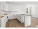 Modern kitchen with white cabinets, countertops, a farmhouse sink, and wood-look floors at 3207 N Florida Ave # 1, Tampa, FL 33603