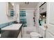 Bright bathroom includes a vanity with black countertop and shower with blue striped curtain at 3425 E Powhatan Ave, Tampa, FL 33610
