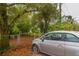 Street view of the home with a peek at the fenced front yard and mature trees at 3425 E Powhatan Ave, Tampa, FL 33610